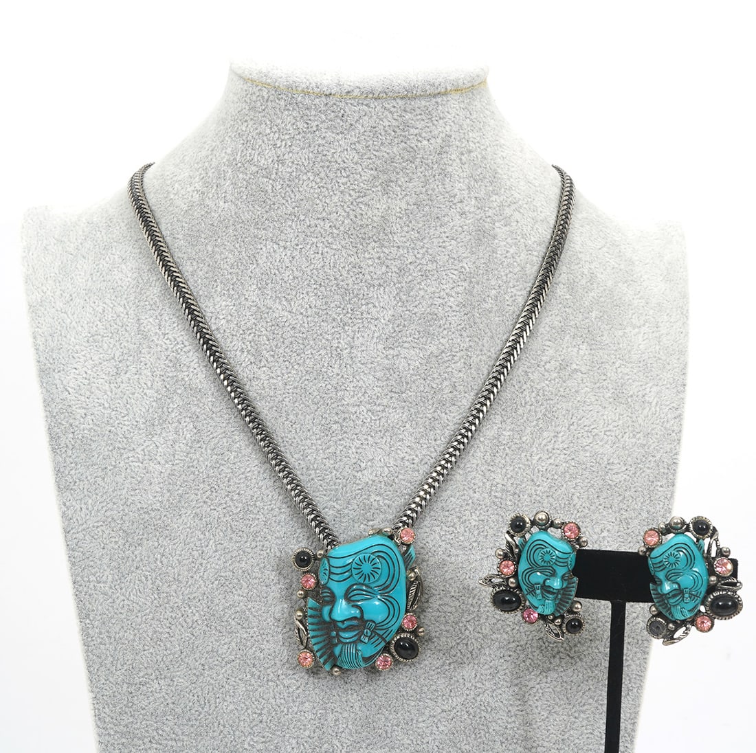 Selro Corp Faux Turquoise Silvertone Jewelry: Selro Corp. Oriental-style jewelry composed of carved faux turquoise and glass stones in white metal setting. Includes pair of clip-on earrings (1.5"L x 1.25"W) and bolo tie with broken ends (buckle m