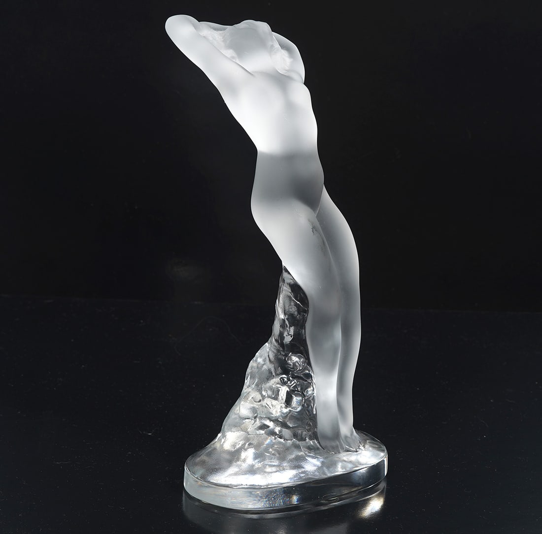 Lalique Crystal 'Danseuse Bras Baisse' Figure: Lalique French crystal 'Danseuse Bras Baisse' figure. Features a frosted and clear female nude signed on base. Measures 9.5"H x 4.5"W. Condition report: Good condition, please see all photos. Contact 