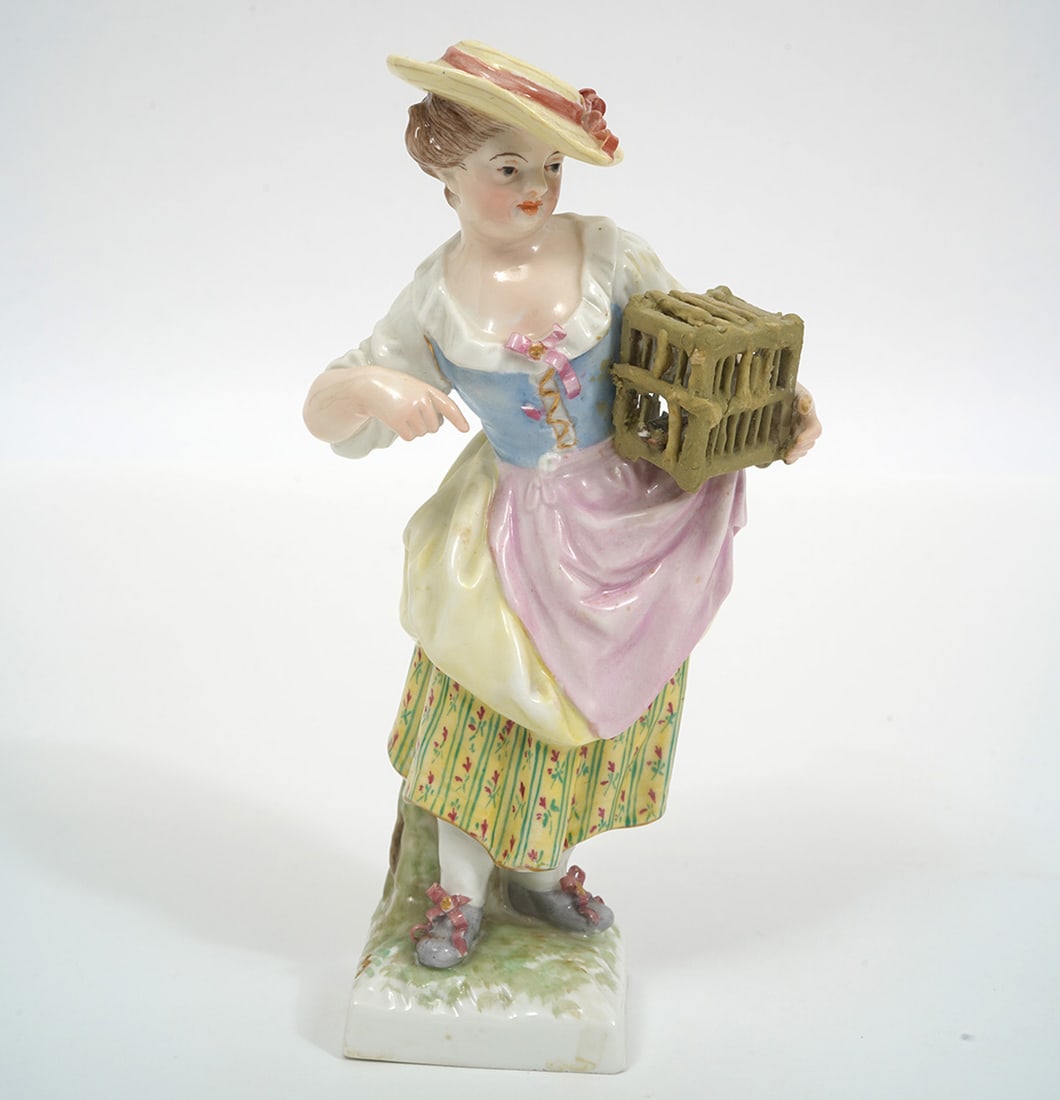 KPM Figurine of Young Lady with Bird Cage: KPM young lady with bird cage porcelain figure, stamped underside. Measures 3"L x 1.75"W x 6"H. Condition report: missing piece on box she is carrying, please see all photos. Contact C. Biddle Auction