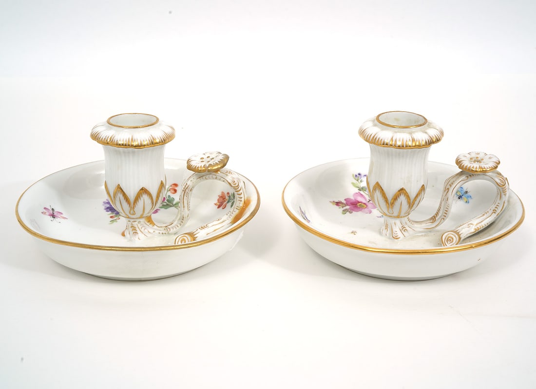 Pair of Meissen German Porcelain Chambersticks: Pair of Meissen German porcelain chambersticks, decorated with gilt and floral patterns. Each measures 3"H x 4.5"W. Hallmarked underside. Condition report: Noticeable repair to one handle, please see 