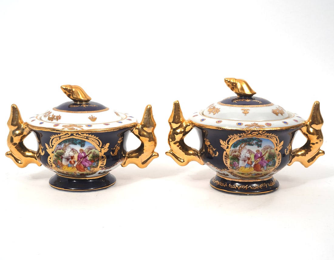 Pr. Serves-Style Porcelain Potpourri Covered Jars: Pair of Serves-style porcelain potpourri covered jars, featuring vignettes of romantic scenes, cobalt and white background and gilt accents. Figural handles and finial. Measures 8.5"H x 6"W. Condition