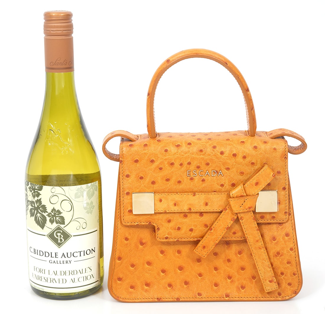 Escada Mini Handle Bag Amber Ostrich Detail: Beautiful amber ostrich detail bag is in original condition with gold plate front logo that has magnetic closure and includes removable shoulder strap. Interior is lined in black suede and has inner c