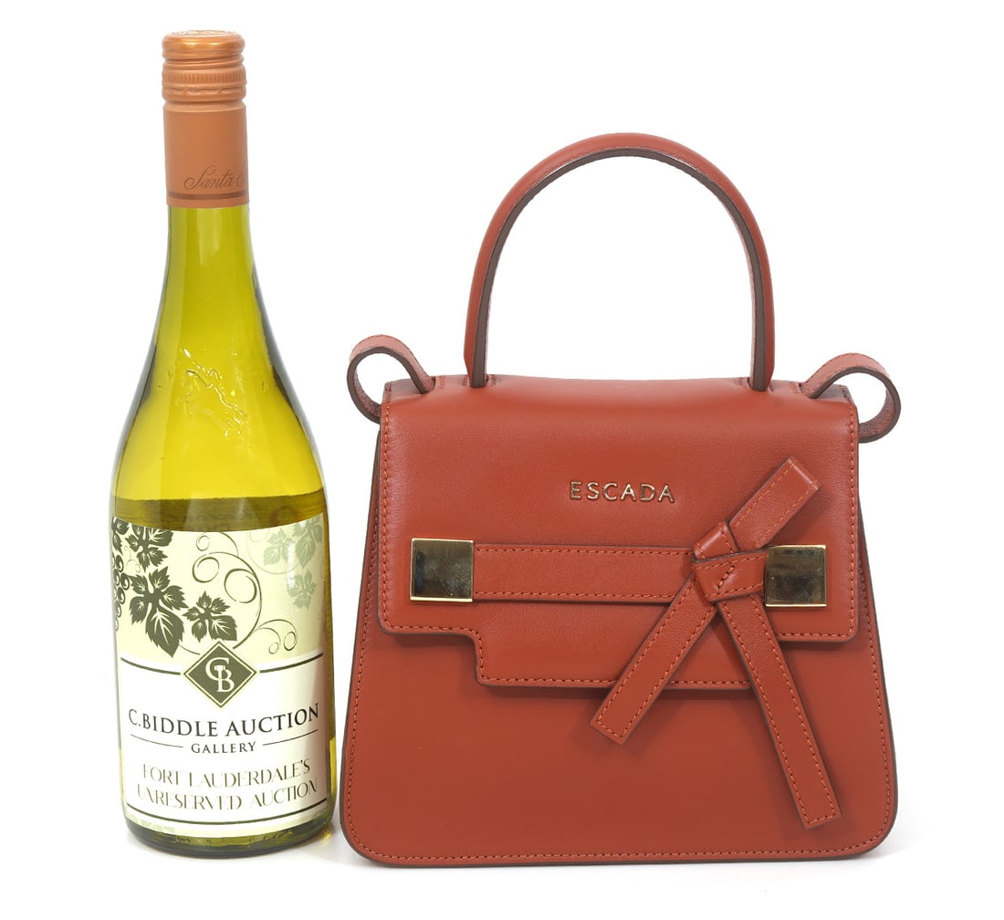 Escada Mini Handle Handbag in Cognac Leather: Beautiful cognac leather bag is in original condition with gold plate front logo that has magnetic closure and includes removable shoulder strap. Interior is lined in black suede and has inner compart