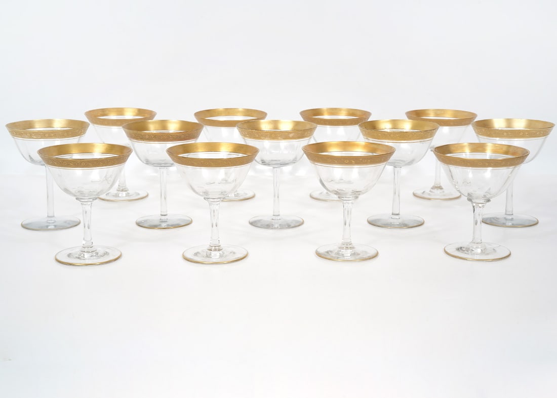 13 Mnton Wine Glasses by Tiffin-Franciscan: 13 Minton hand blown clear water goblets by Tiffin-Franciscan with gold encrusted decorative rim around the top and single gilt rim around the base. Measures 4.75"H x 2.75"W base. Condition report: go