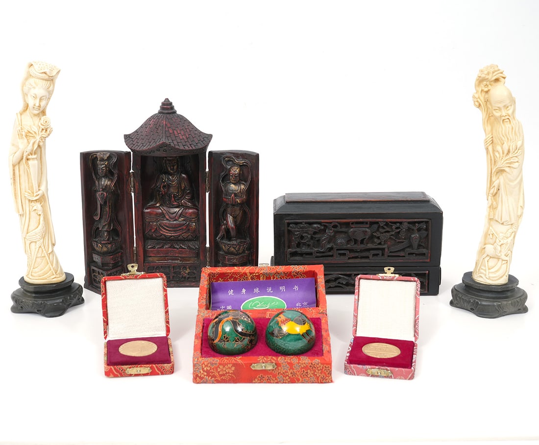 Group of Chinese Decorative Objects: Includes: Pair of carved ancestral figures (12"H x 3"W), tri-figure carved shrine (9.5"H x 3.5"W), carved wood box (8.5"H x 2.75"W x 4.75"H), Two cased medallions, pair of baoding balls. (2"). Conditi