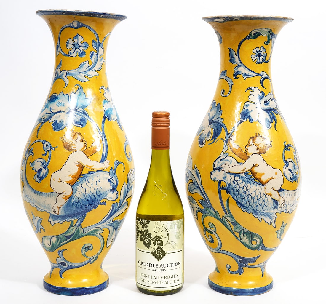 Italian Hand Painted Cherub Dolphins Pottery Vases: Italian hand-painted pottery vases, features cherubs riding dolphins with scrolling leaves. Measures 18"H x 7"W. Condition report: Minor chips to paint, please examine all photos closely. Contact C. B