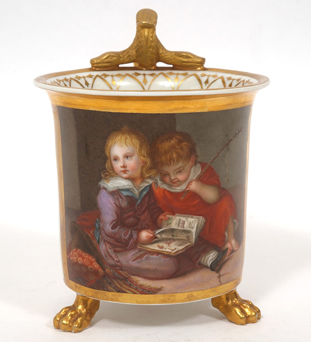 19th C. Meissen Hand-Painted Claw Footed Cup: 19th Century Meissen German tri-footed porcelain cup. Hand-painted with scene of children reading, gilt double snake handle and claw feet. Blue crossed sword mark underside. Measures 4"H x 3.5"W. Cond