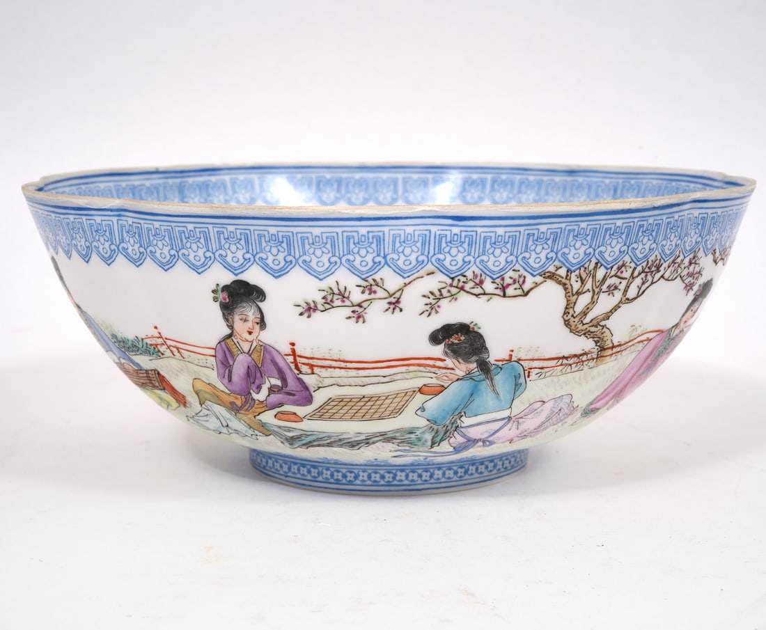 Chinese Eggshell Porcelain Bowl: Chinese eggshell porcelain bowl has a slightly scalloped rim and figures painted around outside in what appears to be a partially fenced garden. There is a blue Chinese seal on the bottom. Measures 2 