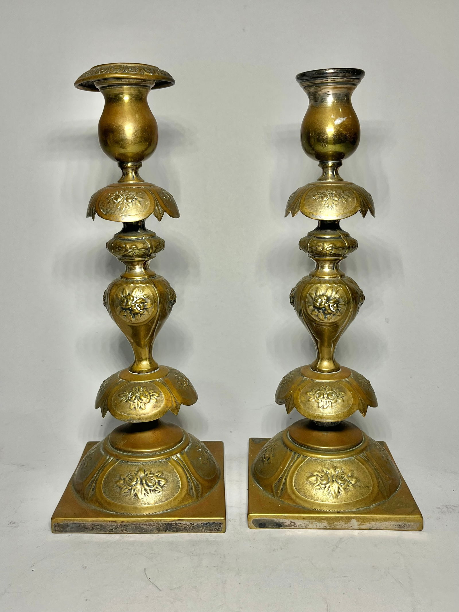 Polished Brass Judaica Shabbat Candlesticks: Polished brass shabbat candlesticks are decorated with hand-made floral pattern. Marked "D. Epstein / Varsovie" alongside other stamps. Measures: 12.5"H x 4.75"W. Condition report: Common wear and den