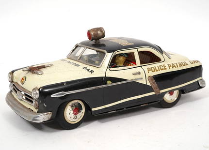Marusan Kosuge 1950's Ford Police Car Tin Toy: Marusan Kosuge 1950's toy Ford police car. Measures 10"H x 4"W x 4"H. Condition report: Good condition, please examine all photos closely. Contact C. Biddle Auction Gallery for more detailed informati