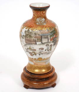 Japanese Satsuma Miniature Signed Vase: Japanese Satsuma miniature signed vase has red character signature on underside and includes a wood stand. The vase is decorated with vignettes of landscapes with figures on two sides. Measures 4''H x