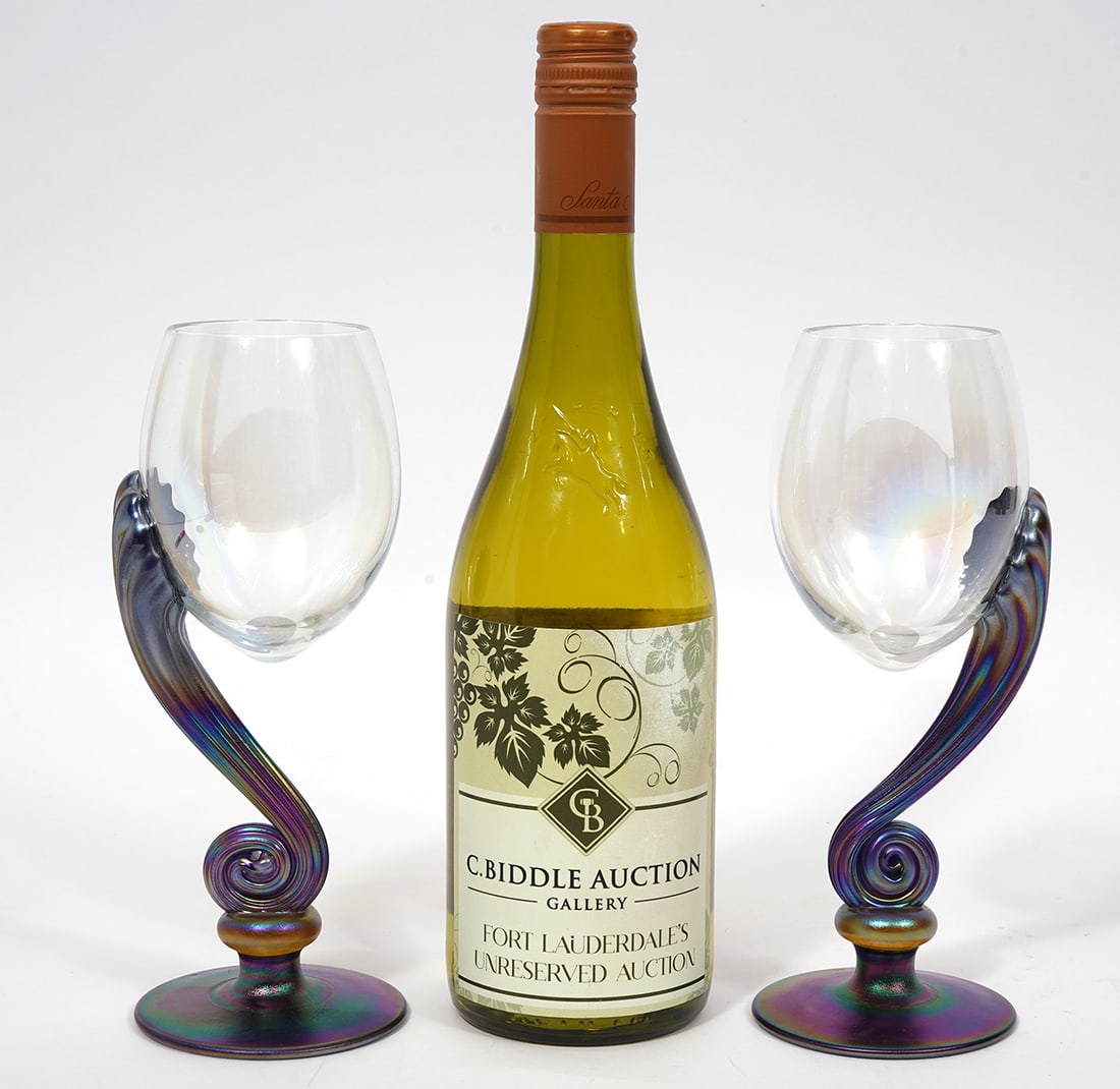 Pair of Igor Muller Iridescent Wine Glasses: Pair of Igor Muller iridescent wine glasses, signed underside and measures 8.5"H. Condition report: Good condition, please examine all photos closely. Contact C. Biddle Auction Gallery for more detail