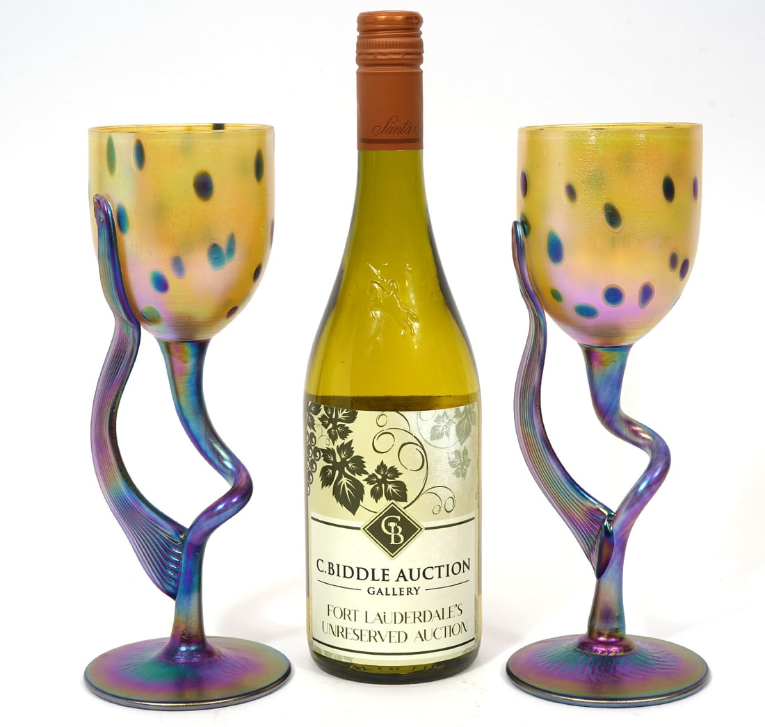 Pair of Igor Muller Iridescent Wine Glasses: Pair of Igor Muller iridescent wine glasses, signed underside and measures 9.75"H x 3.5"W. Condition report: Good condition, please examine all photos closely. Contact C. Biddle Auction Gallery for mo