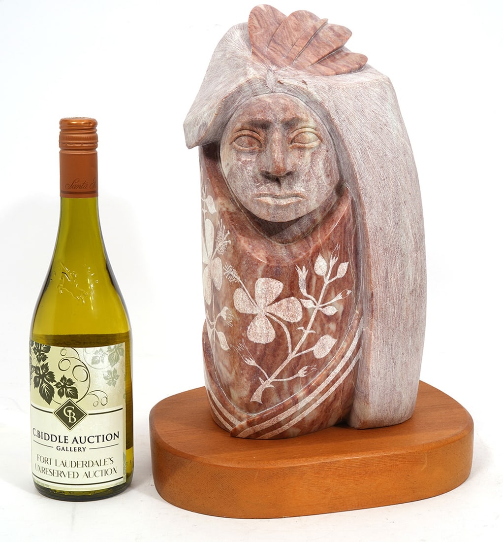 Victor M. Vigil Carved Stone Sculpture: Victor M. Vigil (Native American, New Mexico, b.1957). Carved and etched stone sculpture of a tribesman. Signed at bottom, dated 1992 and mounted on wood plinth. Overall measures 11"H x 10"W x 15.5"D.