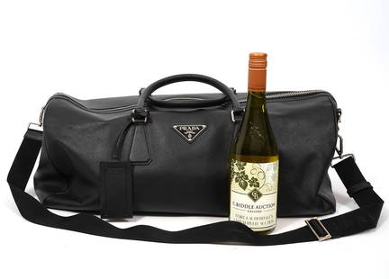 Prada Italy Black Saffiano Leather Duffel Bag: Prada Saffiano black leather duffel bag with silver-tone hardware and shoulder strap. Measures approx 22"L x 10"W x 12"H with a 7" drop. Condition report: Good condition, please see all photos. Contac