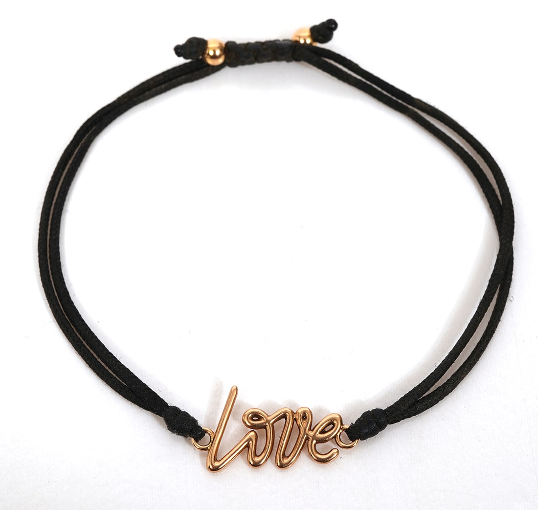Paloma Picasso Tiffany & Co "Love" 18K Bracelet: Paloma Picasso for Tiffany & Co "Love" 18K rose gold bracelet. 'Love' in gold script with a black nylon band is fully hallmarked. Approx. 7.5" circumference. Weight - 2.4g. Condition report: Good cond