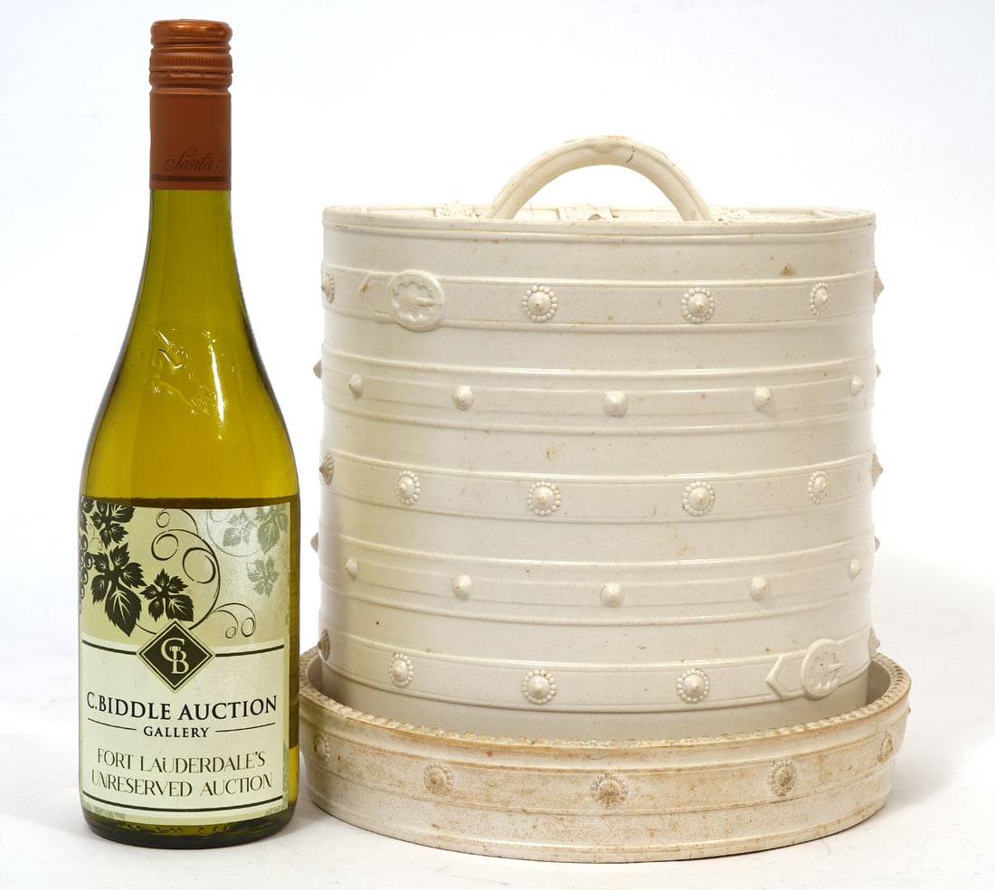 English Creamware Trompe L'oeil Cheese Dome: English creamware trompe l'oeil cheese dome styled as fabric or leather cover with buckles and button accents. Measures 10.5"H x 9"W. Condition report: Hairline crack to top, please see all photos. Co