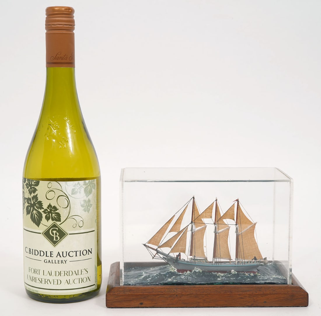 Miniature Model of a Sailing Ship: Miniature model of a sailing ship encased in an acrylic and wood box. Measures 8"L x 4.5"W x 5"H. Condition report: Good condition, please examine all photos closely. Contact C. Biddle Auction Gallery