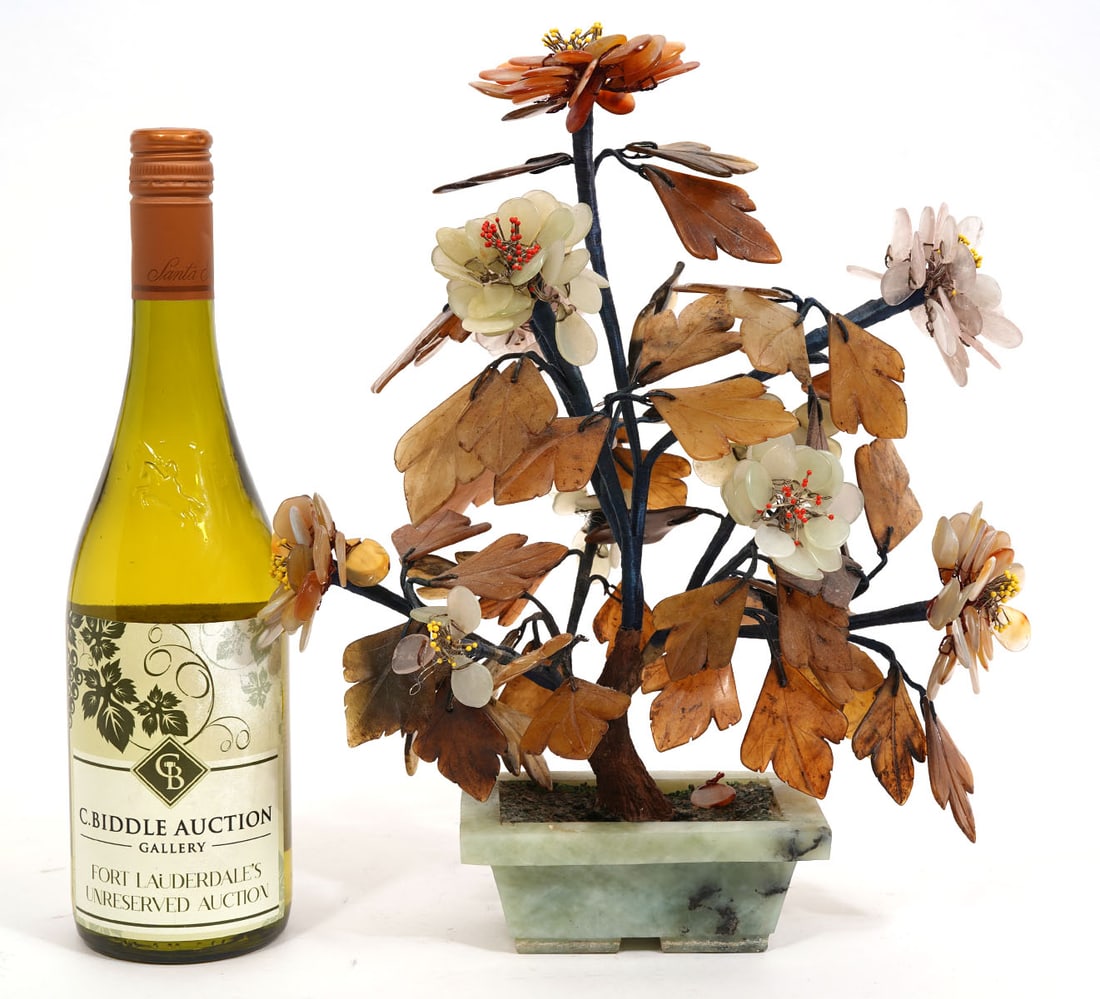 Chinese Hand Carved Bonsai Tree in Jade Base: Chinese bonsai tree with hand carved blossoms and leaves made from jade, agate and hard stones with a rectangular jade base. Measures 13"H x 10"L x 6.5"W; base 3.25"W x 5.25"L x 2"H. Condition report: