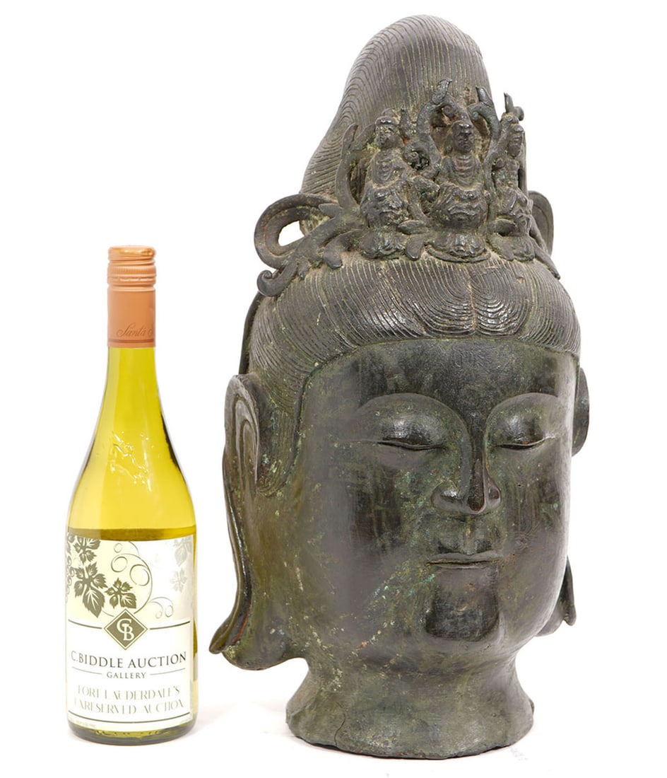 Chinese Buddhist Bronze Head: Chinese Buddhist bronze head features crown with figural design. Measures 9"L x 7.5"W x 17"H. Condition report: Good condition, please examine all photos closely. Contact C. Biddle Auction Gallery for