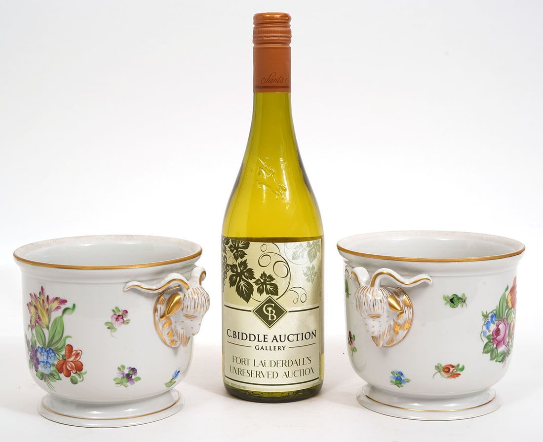 Pr. Herend Porcelain Cachepots: Pair of Herend porcelain cachepots with hand panted florals and ornate ram head handles accented with gilt, marked 'Herend' on bottom. Measures 4.75"H x 7.25"W. Condition report: small flea bite on bo