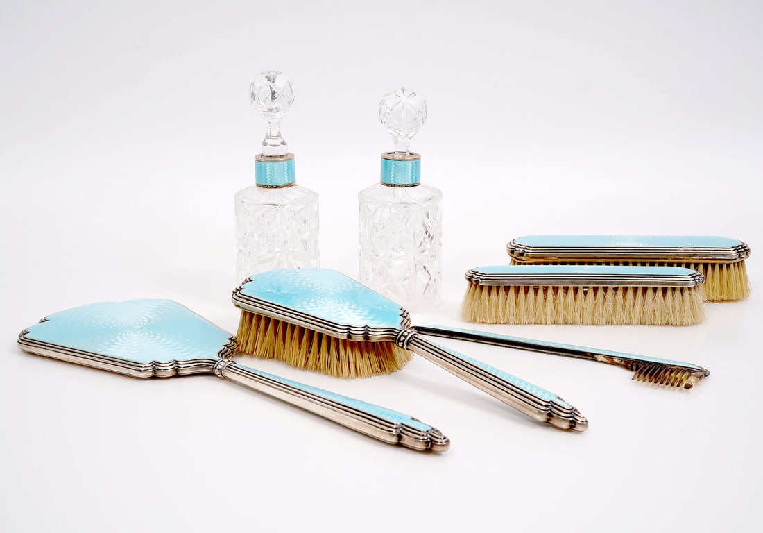 7 Pc. Sterling Guilloche Dresser Set: 7 piece sterling dresser set embellished with turquoise guilloche in precise repetitive patterns. Marked 'Sterling Germany 935'. Set includes a hand mirror (12.75"L x 4 7/8"W); a hairbrush (10"L x 3.2