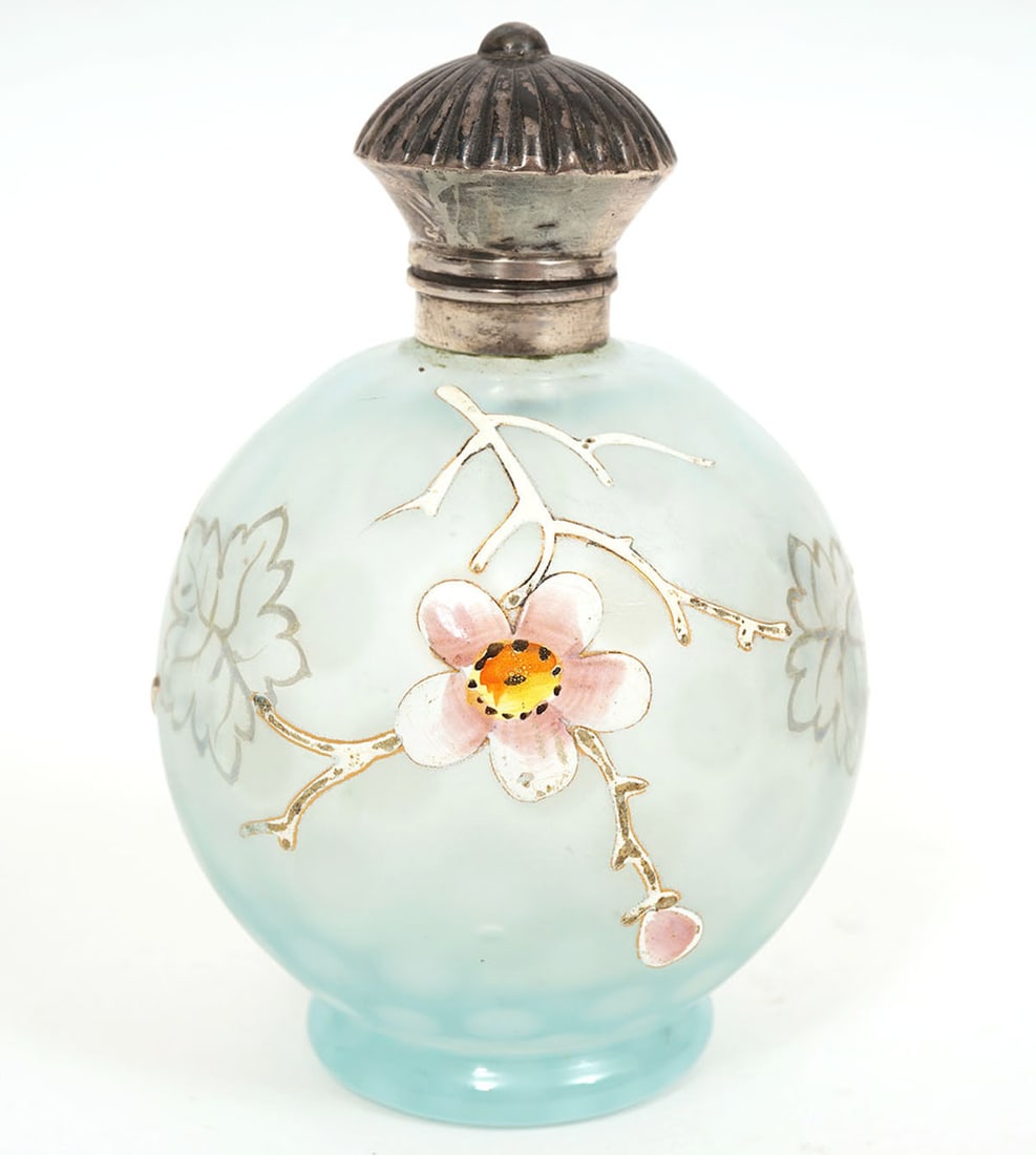 Attributed to Thomas Webb Vintage Perfume Bottle: Vintage perfume bottle attributed to Thomas Webb circa 1890. The silver top is unmarked and the spherical shaped bottle is decorated with hand enameled floral designs. Measures 3 5/8"H x 2 3/8"W. Cond
