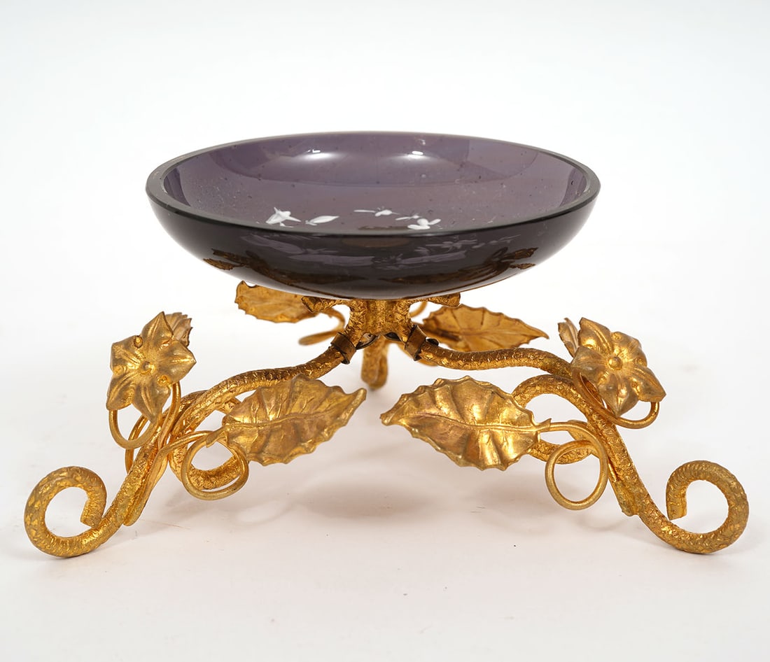 Vintage Enameled Dish on Gilt Metal Stand: Vintage hand enameled small dish mounted on an ornate gilt metal tripod base with floral and leaf motif. Measures 2 1/8"H total; dish 2.75"W; base 4.25" x 4.25" x 4.25". Condition report: good conditi