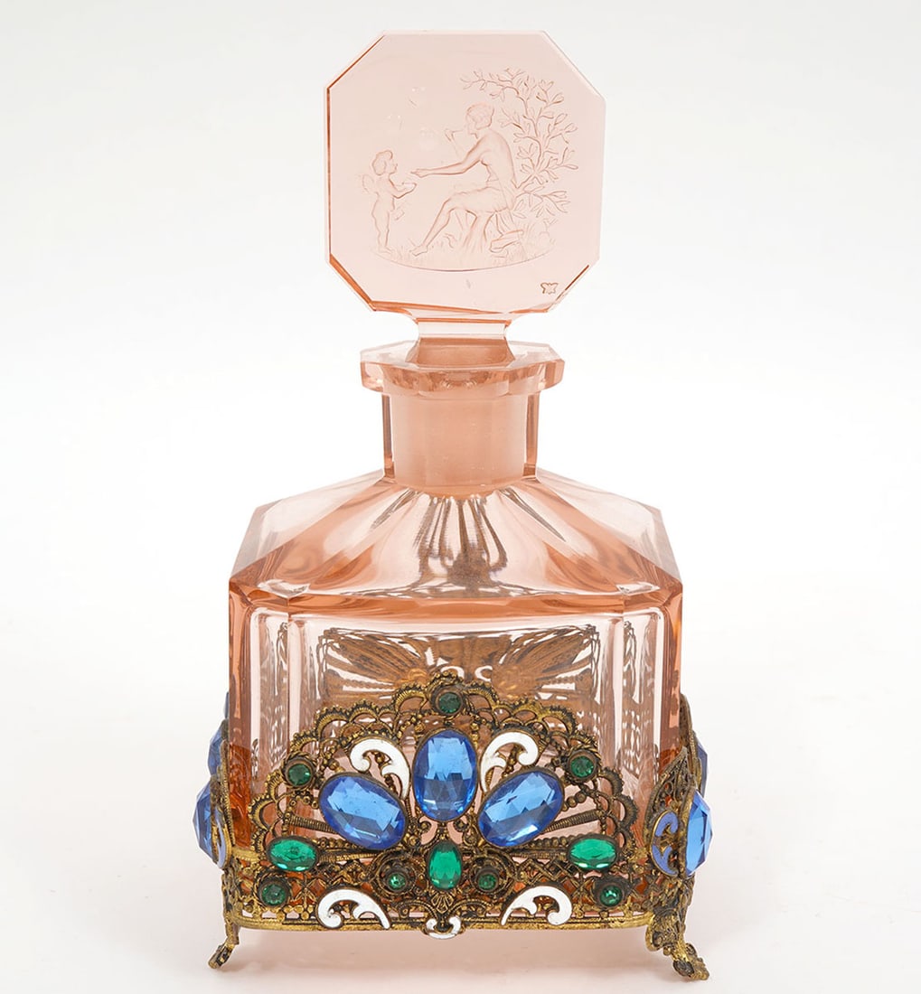 Czech Pink Glass Perfume Bottle Attrib. to Hoffman: Perfume bottle in pink glass with beveled edges attributed to Hoffman is mounted on an enameled and jeweled metalwork base. The stopper is etched with figures of Cupid and a Psyche. Measures 6.75"H to