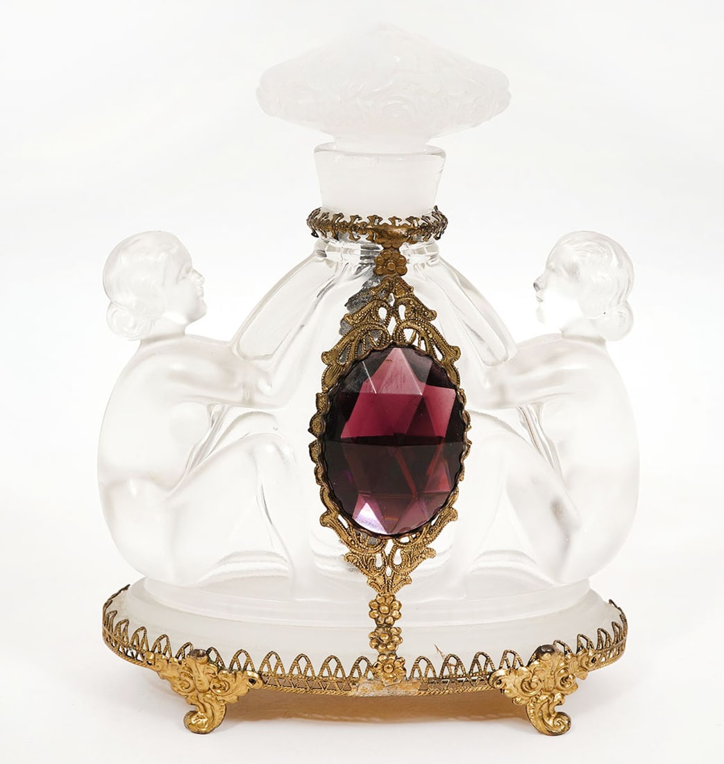 Art Deco Czech Glass Perfume Bottle: Art Deco Czech frosted and clear glass perfume bottle, style of Baccarat, with a sculptured figure on each side. It is on a decorative ornate metal base and there is a large burgundy stone, also metal
