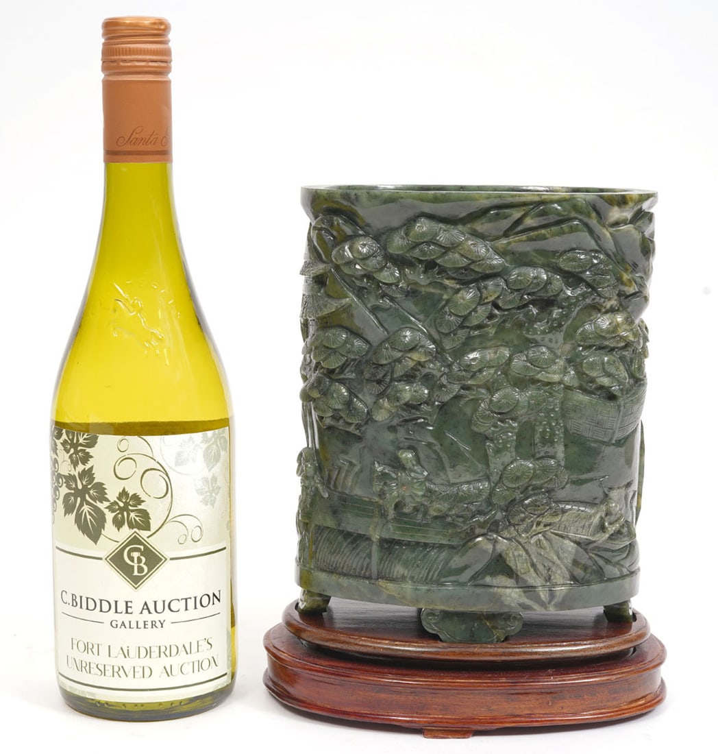 Chinese Carved Spinach Jade Brush Pot: Chinese carved spinach jade brush pot features oval shape with low relief village motif and Chinese characters. Mounted on custom wood base. Overall measures 6.5"L x 4"W x 9"H. Condition report: Good