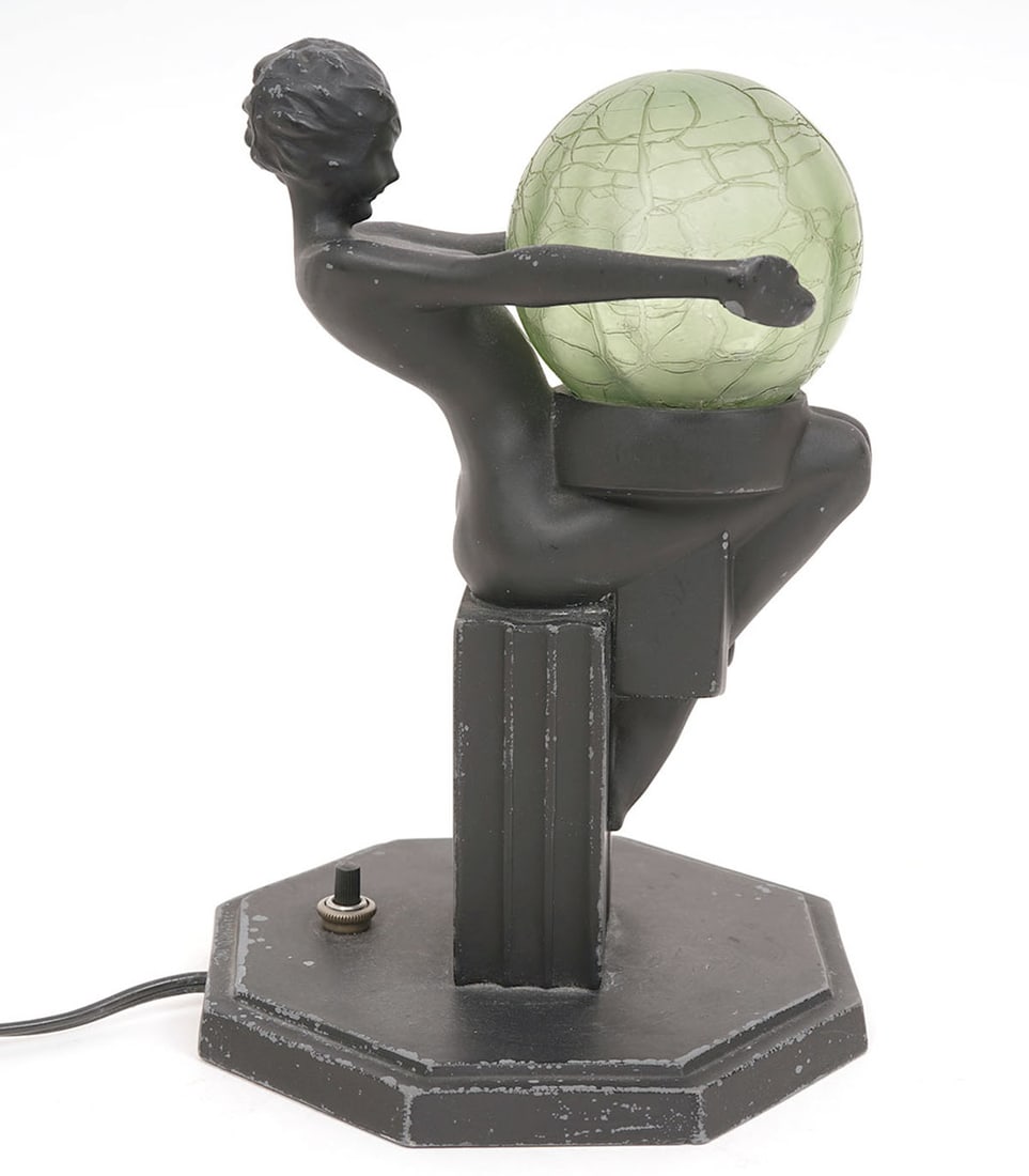 Frankart Art Deco Cast Metal and Glass Lamp: Frankart Art Deco cast metal and glass lamp, painted black, featuring figure reclining on plinth holding globe. Measures 8.5"H x 6"W. Condition report: Minor paint losses, please examine all photos cl