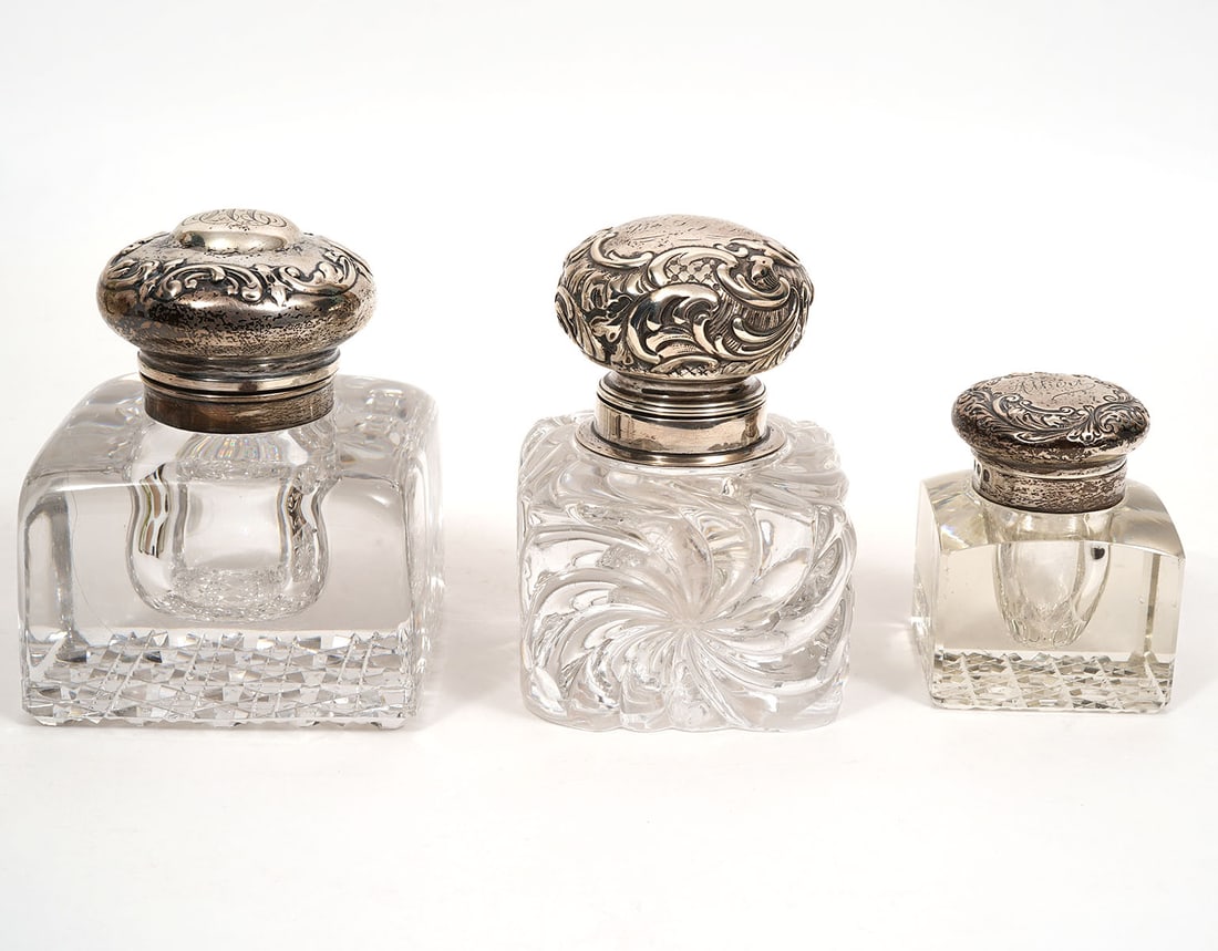 Three English Sterling Top Crystal Inkwells: Three English sterling silver top crystal inkwells includes engraved "Albert" with scrolling leaves sterling top with geometric-cut underside (2"L x 2"W x 2.75"H); Spiral-cut crystal with repousse scr