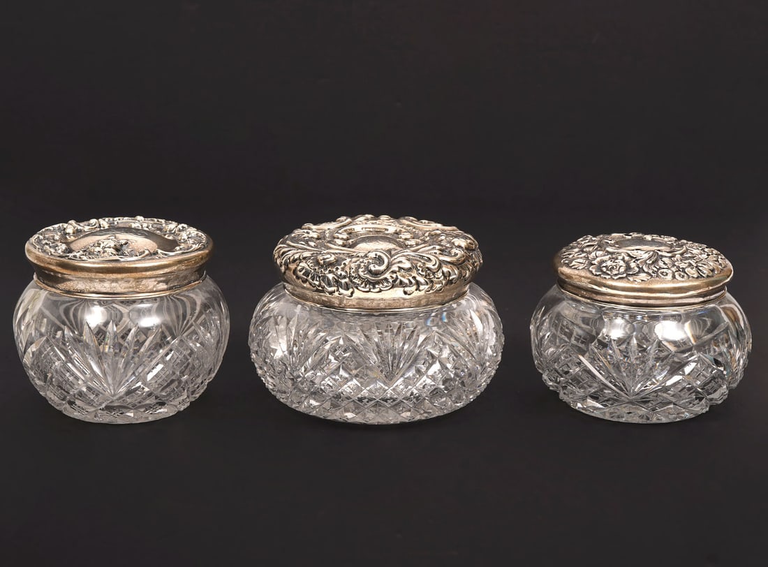 Three Sterling Top Cut-Crystal Vanity Boxes: Sterling top cut-crystal vanity boxes includes: Vanity box with engraved scrolling repousse cross-cut patterns to crystal (3"H x 4.5"W). two smaller (3"H x 3.5"W and 3"H x 4"W) with similar motif. All