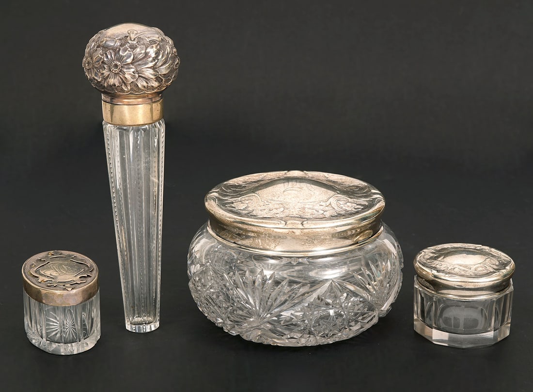 Group of 4 Sterling Silver Crystal Vanity Objects: Group of 4 sterling silver and crystal vanity objects includes a large vanity box with floral engraving and cut crystal (3"H x 4.5"W); lay down perfume bottle (6"L x 2"W); two smaller boxes: oval (1.5