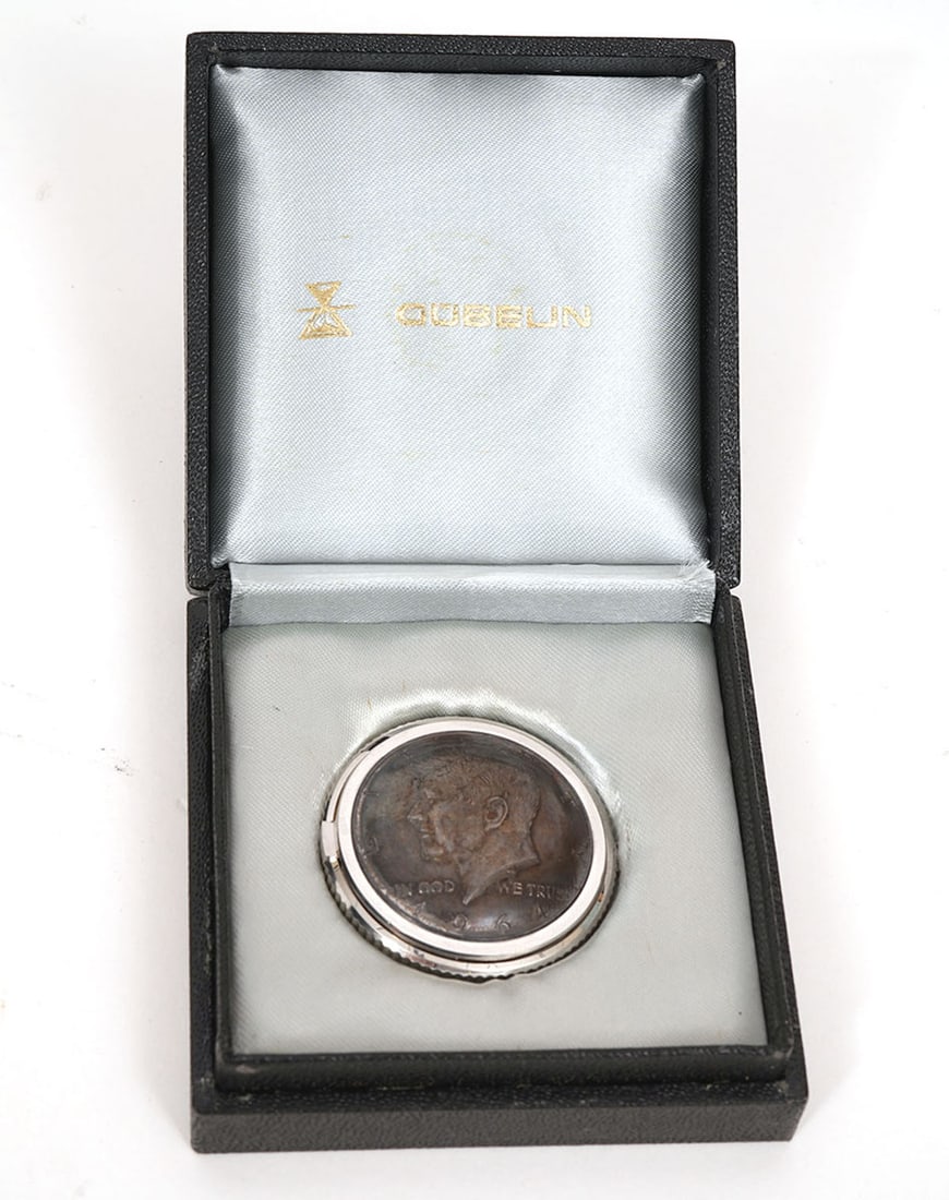 Gubelin JFK Half-Dollar Coin Travel Clock: Gubelin 1964 JFK half-dollar coin travel clock in original case. Measures approx 1.25" in diameter. Condition report: Good condition, please examine all photos closely. Contact C. Biddle Auction Galle