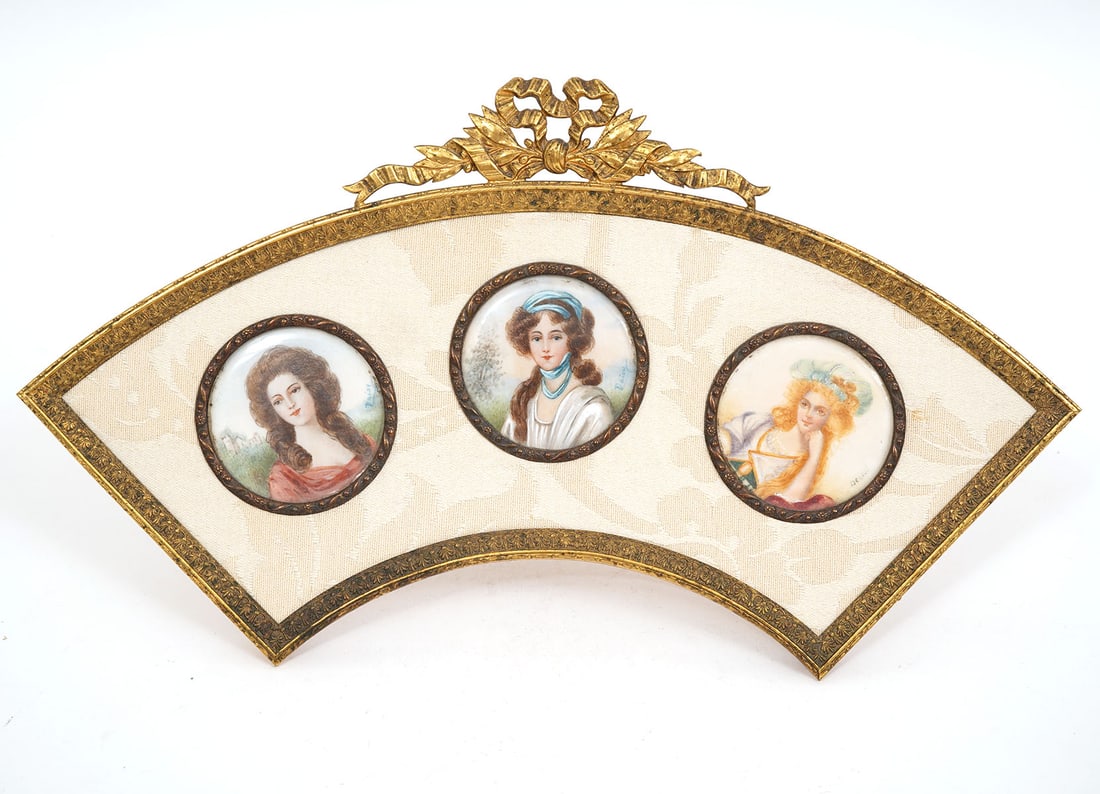 French Bronze Fan-Shaped Triple Portrait Frame: French bronze fan-shaped three portrait frame features bronze easel frame with bow at top, linen matting and contains three hand-painted circular portraits of aristocratic women. Measures 5"H x 10"W.
