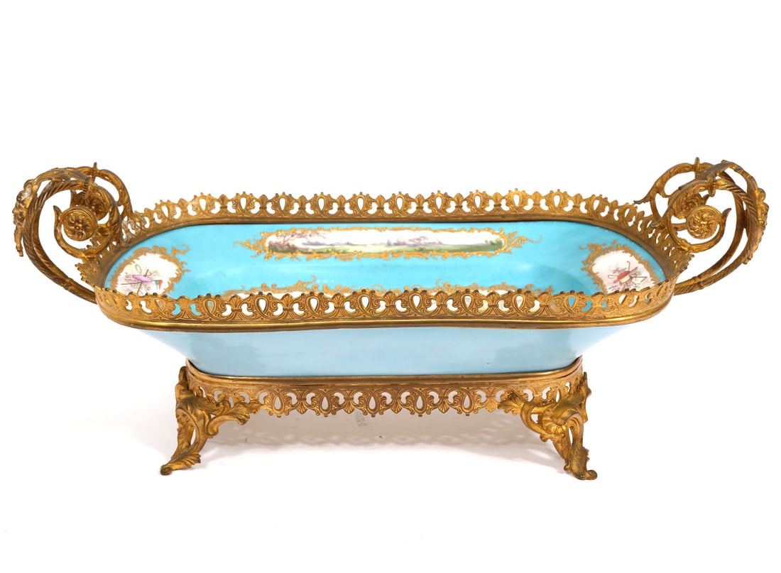 Sevres Porcelain Bronze Mounted Centerpiece: Sevres Chateau de Tuileries, porcelain bronze mounted centerpiece features equestrian horse racing scene in center with four smaller vignettes surrounding and scrolling leafy handles. Hallmarked under