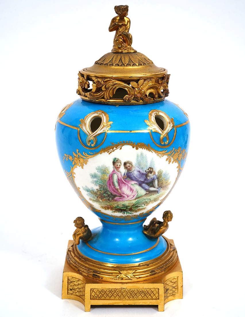 Sevres-Style Porcelain Gilt Bronze Potpourri Urn: Sevres-style porcelain gilt bronze potpourri urn features hand-painted romance themed vignettes with blue background, gilt accents and nude female figures. Measures 10"H x 4"W. Condition report: Good