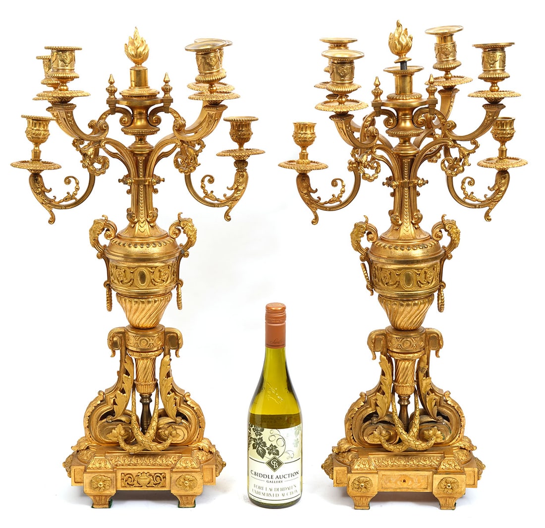 Pr. French Louis XVI-Style Dore Bronze Candelabras: Pair of French Louis XVI-style dore bronze candelabras features four scrolling acanthus leaf motif, Neo-Classical faces and other 18th Century-style decorations. Measures 27"H x 13.5"L x 9.5"W. Condit