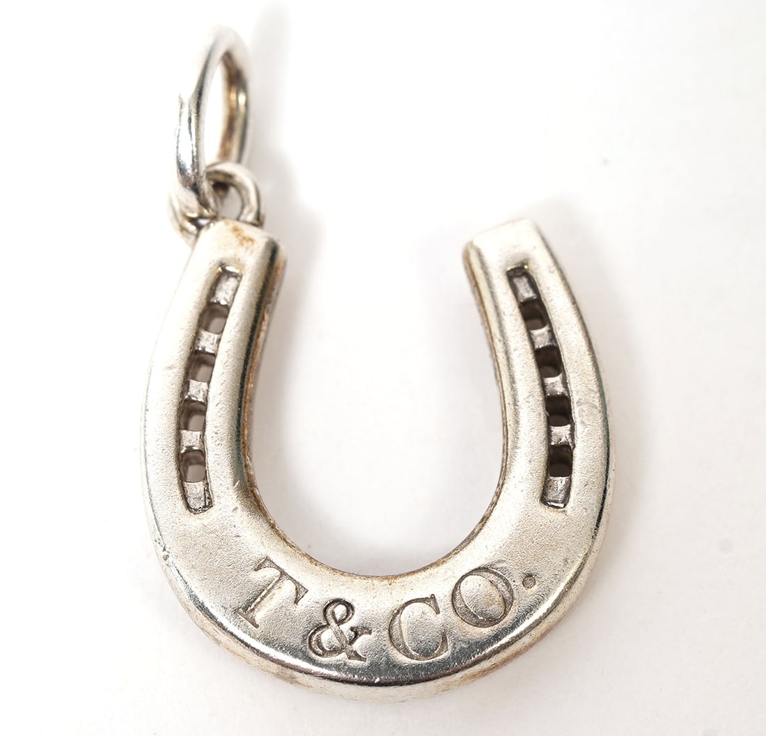 Tiffany & Co. Sterling Horseshoe Charm: Tiffany & Company sterling horseshoe charm or pendant marked Tiffany on both sides and 925 on one side. Measures 5/8"L and weighs 3.3 grams. Condition report: good condition, please see all photos. Co