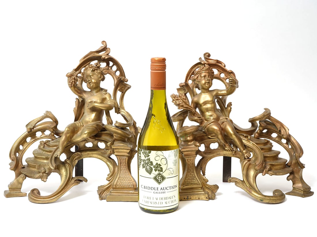 Two French 19th C Louis XV Style Bronze Andirons: Two French 19th C Louis XV style gilt bronze figural andirons, each with a seated cherub resting on a scrolled base with a stairway on one end. Condition report: good condition, scroll backing of one 
