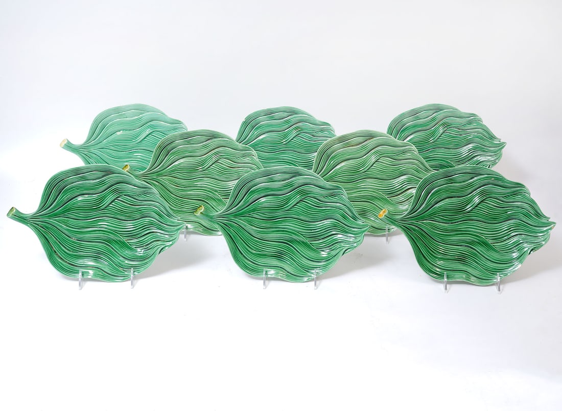 8 Bordallo Pinheiro Green Textured Leaf Platters: 8 Bordallo Pinheiro green textured earthen platters marked on underside 'Made in Portugal 1466'. Measures 12.5"L x 8.5"W x 1.5"H. Condition report: there are 2 flea bites on the edges of 2 plates and 