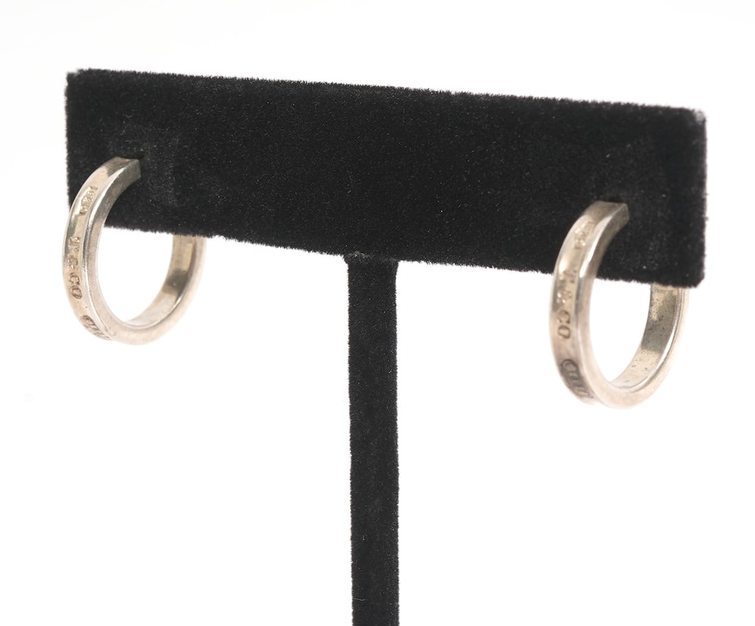Tiffany & Co. Sterling Hoop Earrings: Tiffany & Co. sterling silver hoop pierced earrings that are marked 'T & C 925 1997'. They are 1/2"W and weigh 4.3 grams. Condition report: good condition, please see all photos. Contact C. Biddle