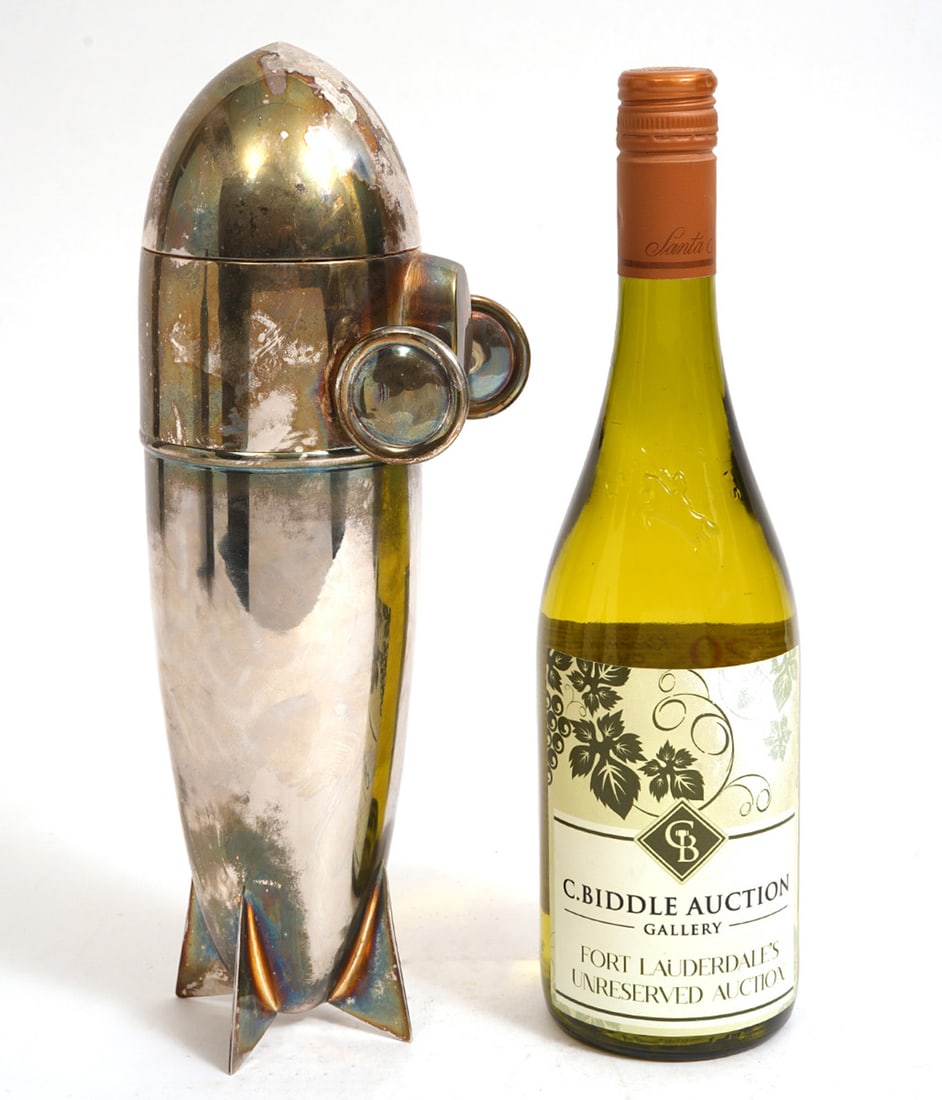 Deco-Style Silver-Plate Zeppelin Cocktail Shaker: Deco-Style silver-plate zeppelin cocktail shaker, unmarked. Measures 12"L x 4.5"H. Condition report: Good condition, please examine all photos closely. Contact C. Biddle Auction Gallery for more detai