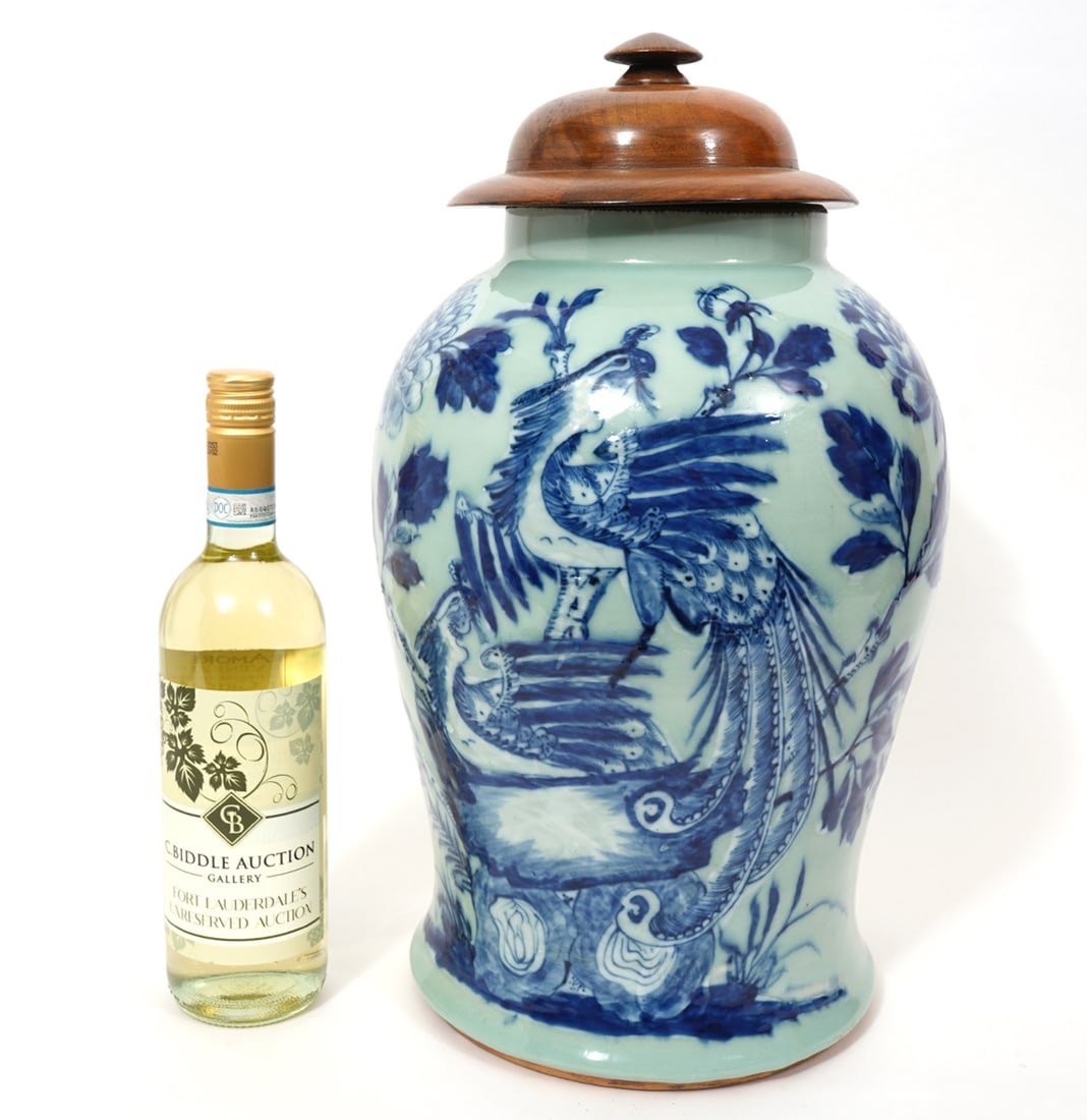 19th C Chinese Porcelain Ginger Jar: Chinese porcelain ginger jar features underglaze blue peacock motifs and a distinctive wooden lid. There are 4 Chinese characters in blue on the underside. Measures 17.5"H with lid; 14.5"H x 9.5"W vas