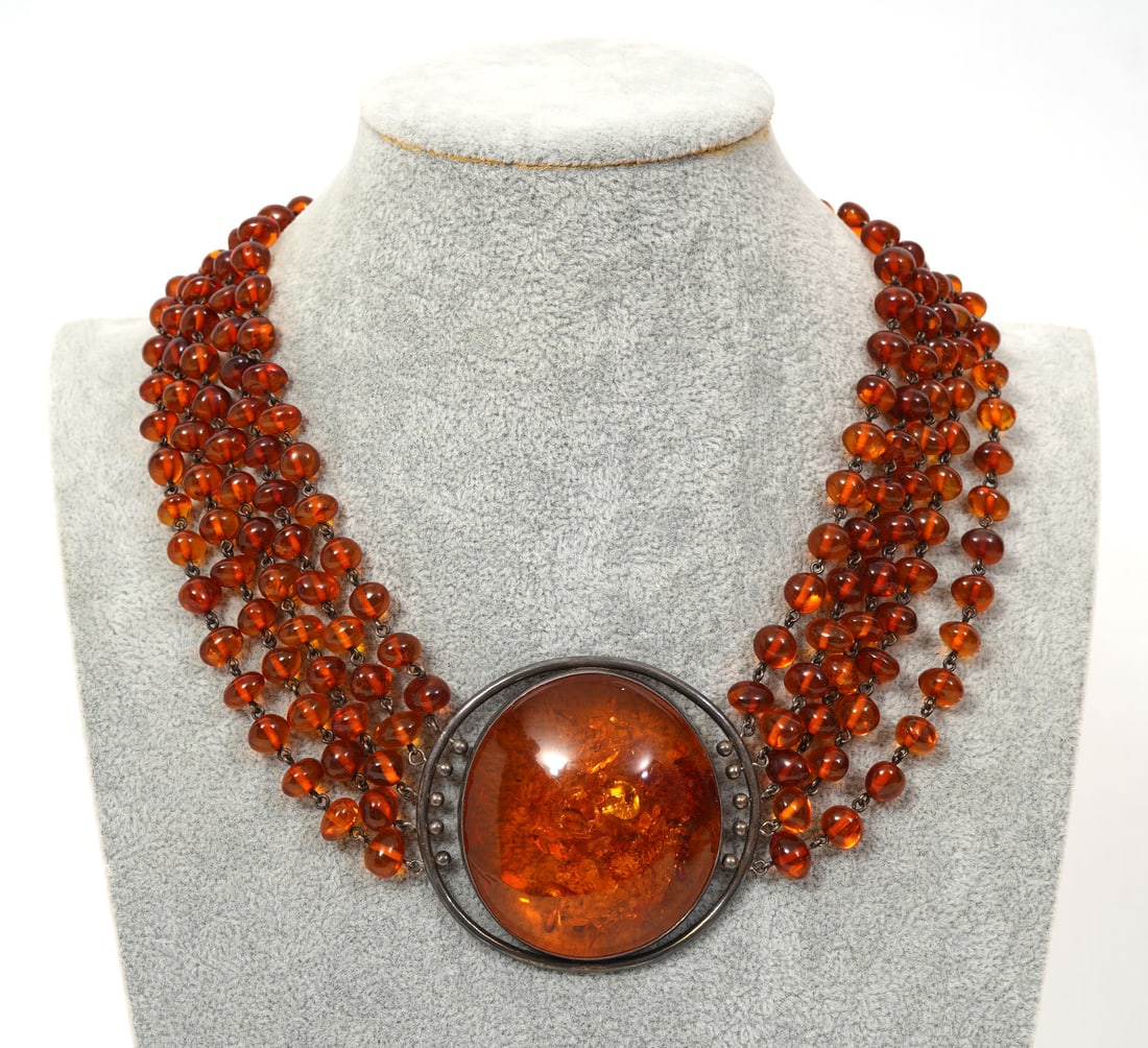 Polish Sterling Silver Baltic Amber Necklace: Polish sterling silver baltic amber necklace composed of large amber cabochons and fives strands of amber beads on each side. Hallmarked on box clasp. Approx - 18" long. Condition report: Good conditi