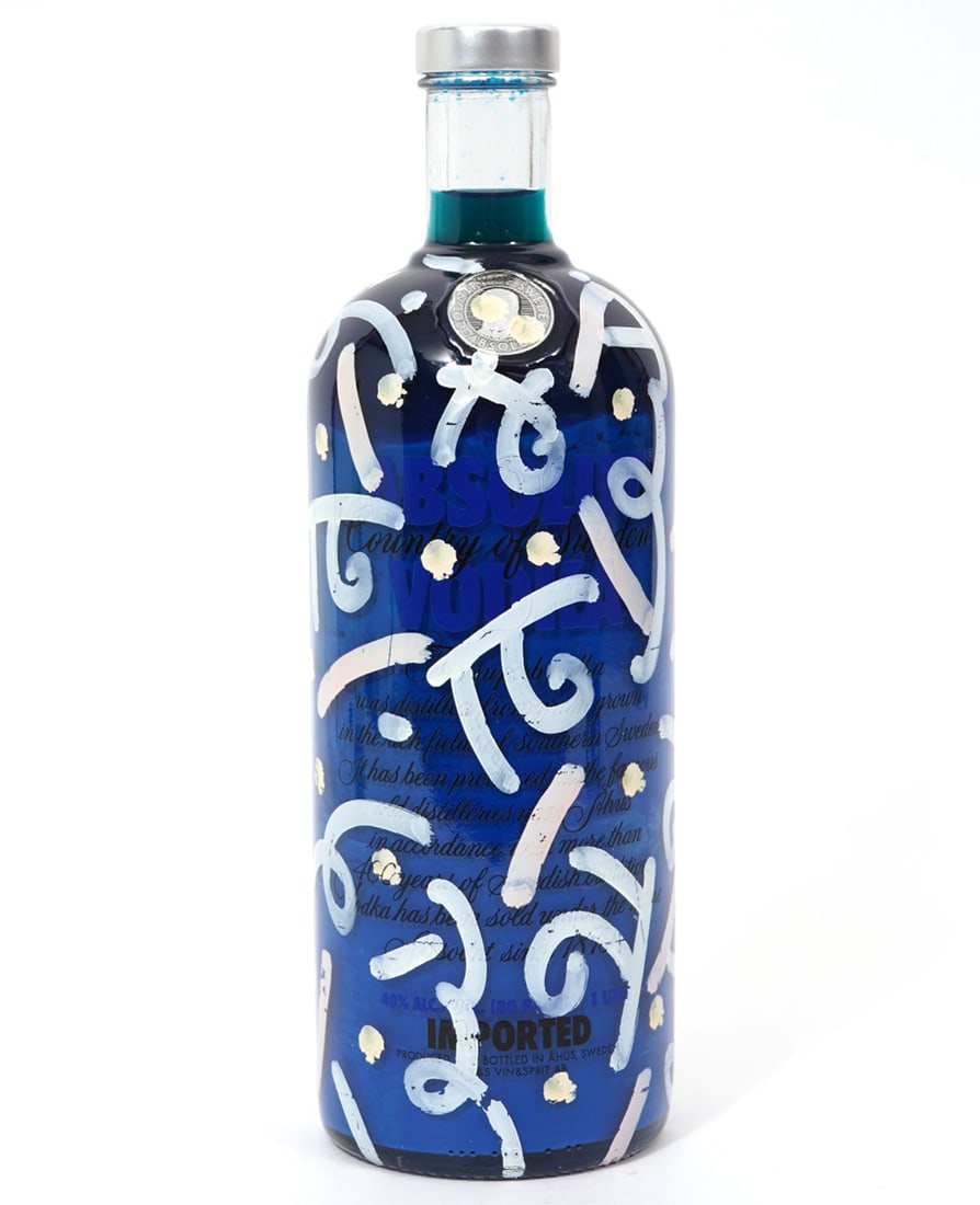 Romero Britto 'Absolutely Vodka' Painted Bottle: Romero Britto, Brazil (Born 1963). A bottle of Absolut Vodka decorated with white highlights and signed on side. This bottle is filled with blue liquid and has original circular label. Measures 11"H x