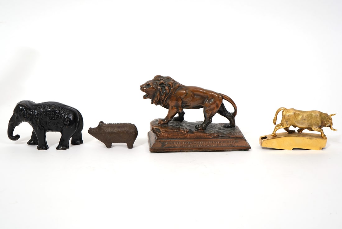 Group of Four Metal Animal Figures: Group of four metal animal figures includes MGM Lion paperweight (5"L x 2.5"W x 3.25"H), "Birmingham" cast iron pig (2.25"), Gilt metal bull ornament (2"H x 3.5"W), Cast Iron Advertising elephant "Ind