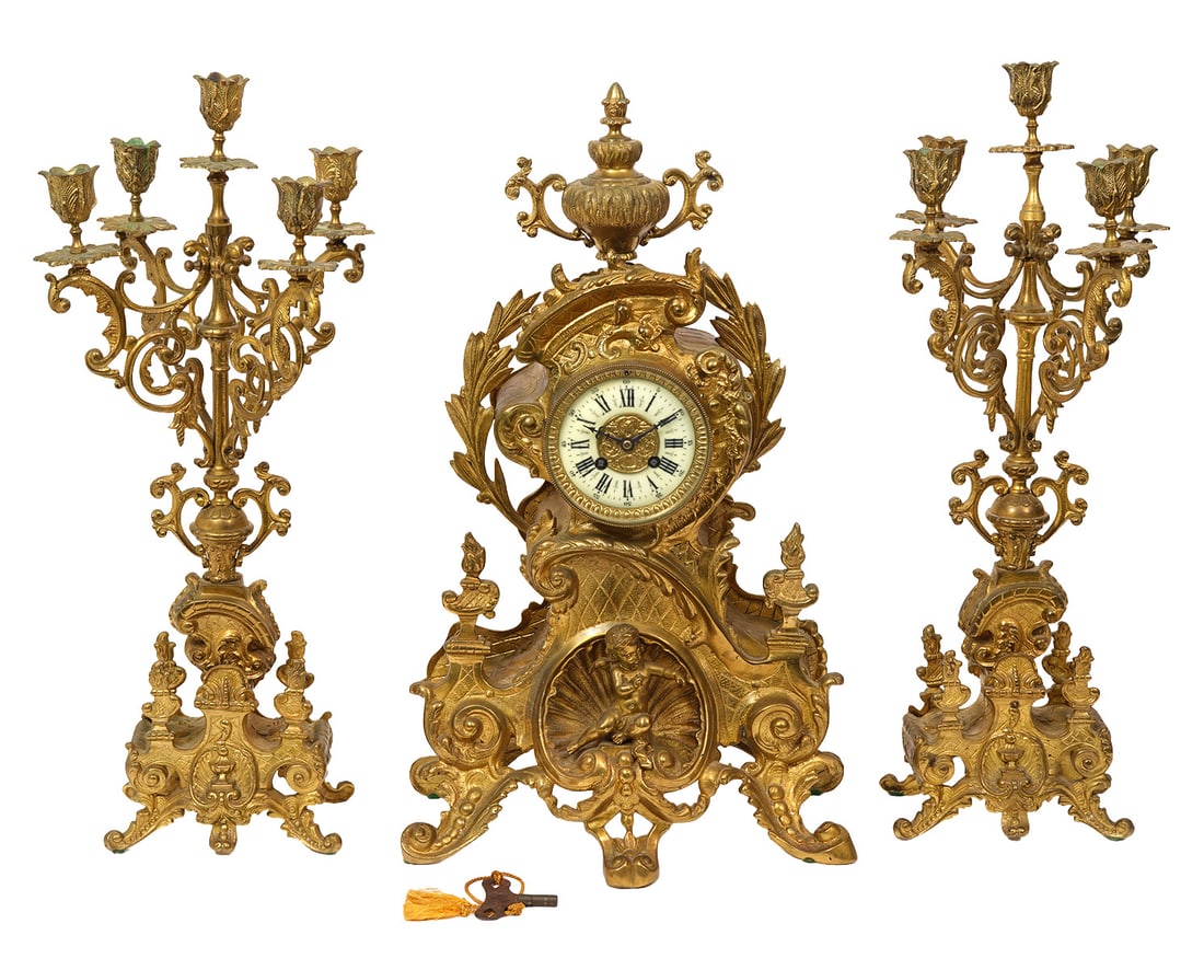 French Louis XV-Style Bronze 3Pc Garniture Set: French Louis XV-style bronze 3 piece garniture set includes Mantle clock (13"L x 7.5"W x 22"H) and includes winding key. Pair of bronze candelabras (22"H x 8"W). Condition report: Good condition, comm